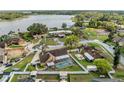 Serene waterfront property featuring a screened pool, lush landscaping, and a charming neighborhood setting at 2912 Spaniel Ln, Seffner, FL 33584