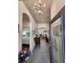Inviting foyer with tiled floor, decorative lighting, and an open view into other rooms at 3215 Coconut Grove Rd, Land O Lakes, FL 34639