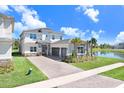 Beautiful two-story home with stone accents, a three-car garage and a brick paved driveway, located near a pond at 32423 Rosewood Meadow Ln, Wesley Chapel, FL 33543