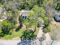 Aerial view of a home with a well-maintained lawn, mature trees, and brick paver driveway at 405 Apache Trl, Brandon, FL 33511