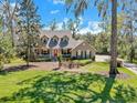 Two-story home with a red front door, nestled within a picturesque landscape at 405 Apache Trl, Brandon, FL 33511