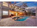 Inviting backyard pool with a screened enclosure and brick paver patio, perfect for entertaining at 405 Apache Trl, Brandon, FL 33511