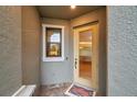 Inviting entryway featuring a sidelight window and a decorative welcome mat at 5086 San Martino Dr, Wesley Chapel, FL 33543