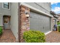 Spacious two-car garage with brick accents and exterior lighting at 5086 San Martino Dr, Wesley Chapel, FL 33543