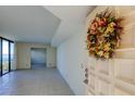 Welcoming condo entryway featuring neutral tile, white doors, and a vibrant floral wreath at 5729 Puerta Del Sol Boulevard South # 486, St Petersburg, FL 33715
