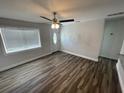 Bright living room with modern ceiling fan, wood-look flooring and a glass adorned front door at 645 38Th S Ave, St Petersburg, FL 33705