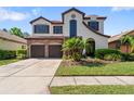 Charming two-story home featuring a stone accent wall and a spacious two-car garage at 8235 Dunham Station Dr, Tampa, FL 33647