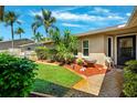 Well-maintained home featuring a decorative lawn, mature landscaping, and a brick-paved walkway leading to the front door at 8621 Bridgewater Dr, New Port Richey, FL 34655