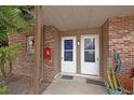 Front door entrance featuring neutral brick, two white doors, and potted cactus at 10423 Carrollbrook Cir # 102, Tampa, FL 33618