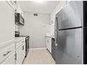 Modern kitchen featuring stainless steel appliances, white cabinets, and tile flooring at 10423 Carrollbrook Cir # 102, Tampa, FL 33618