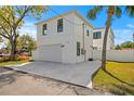 Bright, white two-story home with a two-car garage and concrete driveway at 1239 36Th N Ave, St Petersburg, FL 33704