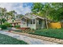Exterior view of a bungalow with lush landscaping, brick walkway, and cozy front porch at 129 18Th N Ave, St Petersburg, FL 33704
