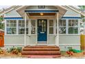 Welcoming front porch featuring a brick stairway, blue door, and ample natural light at 129 18Th N Ave, St Petersburg, FL 33704