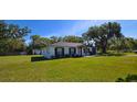 Well-maintained home with a lush green lawn and mature trees, providing a serene outdoor space at 1413 Lithia Pinecrest Rd, Brandon, FL 33511
