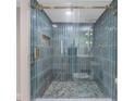 Updated walk-in shower featuring stylish blue tiling and glass door at 1941 48Th S St, St Petersburg, FL 33711