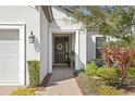 Inviting entryway with brick pathway, decorative wreath, and manicured shrubs at 20173 Umbria Hill Dr, Tampa, FL 33647