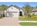 Charming one-story home with lush landscaping, brick driveway, and a two-car garage at 20173 Umbria Hill Dr, Tampa, FL 33647