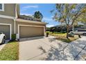 Attractive townhome with an attached garage, well-kept lawn, and a scenic view of the pond at 3019 Old Fulton Pl, Brandon, FL 33510