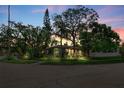 Home with mature trees at dusk at 325 Orangeview Ave, Clearwater, FL 33755
