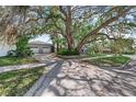 Lovely home with a lush tree in the yard and a two-car garage, enhanced by verdant landscaping at 325 Orangeview Ave, Clearwater, FL 33755