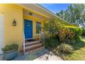 Close-up of the charming blue front door with decorative wreath and well-kept landscaping at 419 Richards Ave, Clearwater, FL 33755