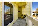 Inviting balcony featuring bright yellow walls, wood accents, and a potted plant, creating a cozy outdoor space at 455 Alt 19 S # 162, Palm Harbor, FL 34683
