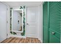 A charming hallway with a mirror, stylish wall decor, wood-look flooring, and a bright green closet door at 455 Alt 19 S # 162, Palm Harbor, FL 34683