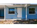 Close-up of the front door, showcasing the covered porch and surrounding windows at 4716 Town N Country Blvd, Tampa, FL 33615