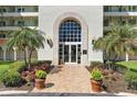 Elegant building entrance with arched doorway, palm trees, and meticulously maintained landscaping at 4801 Osprey S Dr # 404, St Petersburg, FL 33711