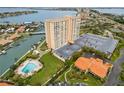 Stunning aerial view of the condo building with water views, a pool, and manicured grounds at 4900 Brittany S Dr # 205, St Petersburg, FL 33715