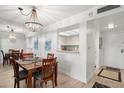 Dining room featuring a modern chandelier, seating for four, and an open view to the kitchen at 4900 Brittany S Dr # 205, St Petersburg, FL 33715