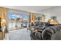 Living room with comfortable gray sofa, large windows to balcony, and decorative rug at 4900 Brittany S Dr # 205, St Petersburg, FL 33715