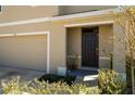 Close-up of the front door and entry, showing the clean lines, neutral paint, and well-kept landscaping at 5764 Hollingworth Trl, Wesley Chapel, FL 33545