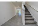 Open hallway features ceramic tile flooring and a staircase leading to the upper level of the home at 5764 Hollingworth Trl, Wesley Chapel, FL 33545