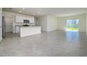 Open-concept kitchen and living area with ceramic tile flooring and bright natural light at 5764 Hollingworth Trl, Wesley Chapel, FL 33545