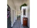Inviting hallway leads to the living area, accentuated by stylish wood flooring and decorative plants at 7530 Roy Ct, New Port Richey, FL 34654