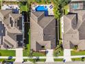 Birds-eye view of a well-maintained home with pool and solar panels in a neatly planned community at 8307 Bluevine Sky Dr, Land O Lakes, FL 34637