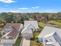 Beautiful home and landscaping with a white tile roof and brick driveway on a sunny day in a scenic neighborhood at 9339 Creole Ct, Weeki Wachee, FL 34613
