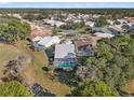 Neighborhood aerial view of a home with a screened-in pool, surrounded by lush trees and well-maintained lawns at 9339 Creole Ct, Weeki Wachee, FL 34613
