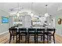Full view of kitchen island and seating with pendant lights, skylight, and eat-in-kitchen in the background at 9466 127Th Ave, Largo, FL 33773