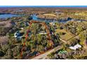 Expansive aerial view showcasing the property's acreage, mature trees, and lake access at 10101 Tarpon Springs Rd, Odessa, FL 33556