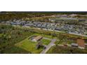 Aerial view showcasing a neighborhood, with focus on a home featuring a screened pool at 10603 1St St, Riverview, FL 33569