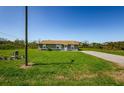 Cozy one-story home with a green lawn, a paved driveway, and a simple, attractive exterior at 10603 1St St, Riverview, FL 33569