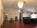 Open living room with hardwood floors, chandelier, and ample space for entertaining and relaxation at 11716 Cr 672 Hwy, Riverview, FL 33579
