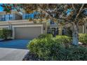 Charming townhome featuring a landscaped front yard and an attached two-car garage at 13207 San Blas Loop, Largo, FL 33774