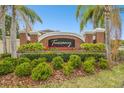 Community entrance sign surrounded by landscaped foliage and brick columns at 16011 Bella Woods Dr, Tampa, FL 33647