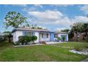 Single-story home featuring a well-manicured lawn, a blue painted garage door, and blue shutters at 2448 14Th S Ave, St Petersburg, FL 33712