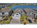 An aerial view showcases the beautiful home and its proximity to the lake, surrounded by well-maintained landscaping at 3139 Marine Grass Dr, Wimauma, FL 33598