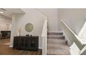 Inviting entryway featuring wood-look tile flooring, a staircase, and stylish decor, creating a warm and welcoming atmosphere at 3139 Marine Grass Dr, Wimauma, FL 33598