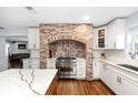 Modern kitchen featuring a brick oven hood, stainless steel appliances, custom cabinetry and counter tops at 37420 Meridian Ave, Dade City, FL 33525
